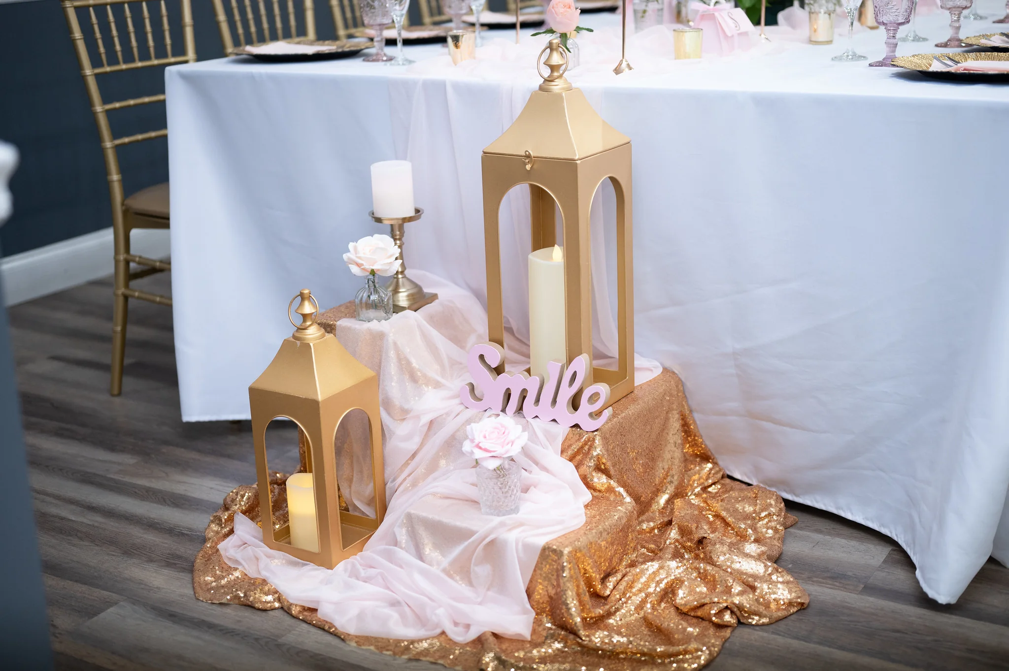 Los Olivos wedding decor detail with gold lanterns and soft pink fabric