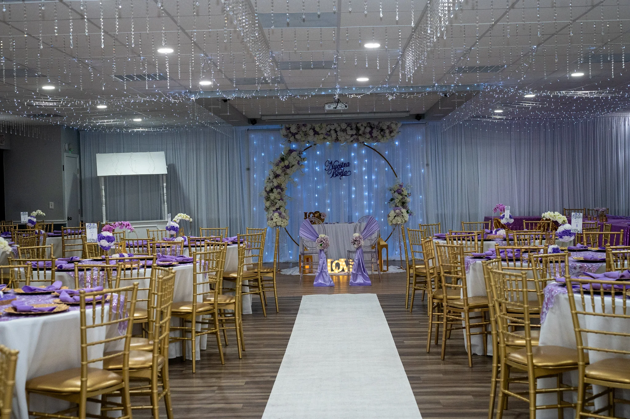 Los Olivos reception room set with gold chairs and purple table decor